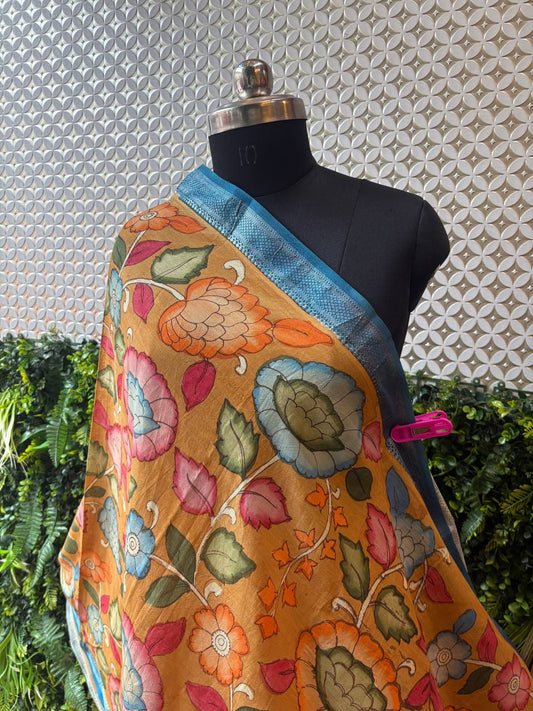 A close-up shot of the pink Kalamkari dupatta draped on a mannequin, highlighting the texture of the cotton-silk fabric and the blue floral print.