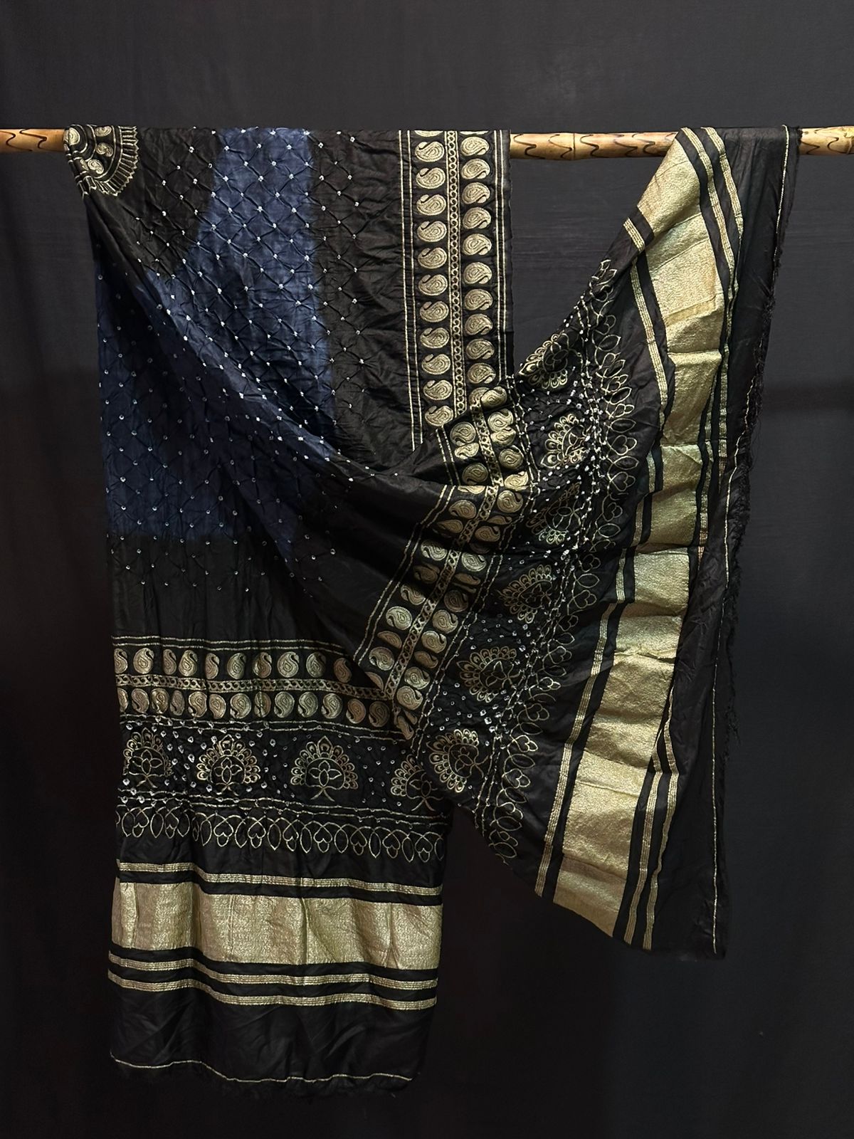 A classic black Gajji silk Bandhani dupatta with a grey-blue tie-dye section and a contrasting heavy gold Zari border.