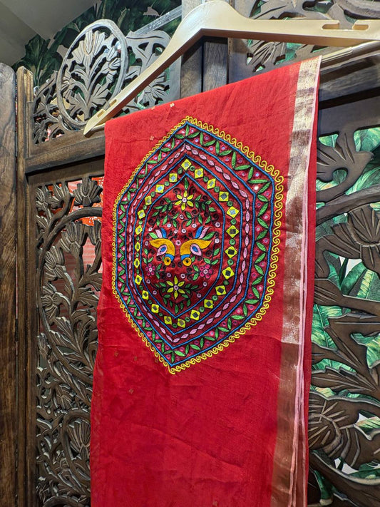 Full view of the Ruhani red organza saree hanging on a hanger, showcasing the large Kutchi embroidery patch on the pallu