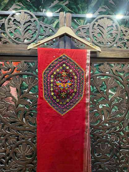 Close-up of the handcrafted Kutchi embroidery medallion on the pallu of the red organza saree, featuring central bird motifs and shimmering mirror work.