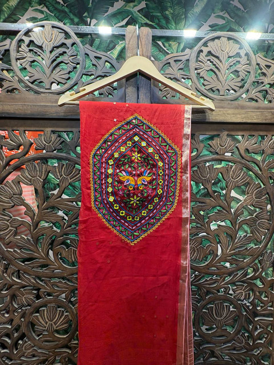 Close-up of the handcrafted Kutchi embroidery medallion on the pallu of the red organza saree, featuring central bird motifs and shimmering mirror work.