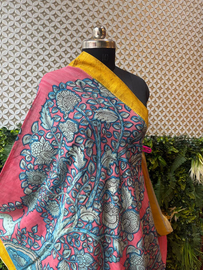  A close-up shot of the pink Kalamkari dupatta draped on a mannequin, highlighting the texture of the cotton-silk fabric and the blue floral print.