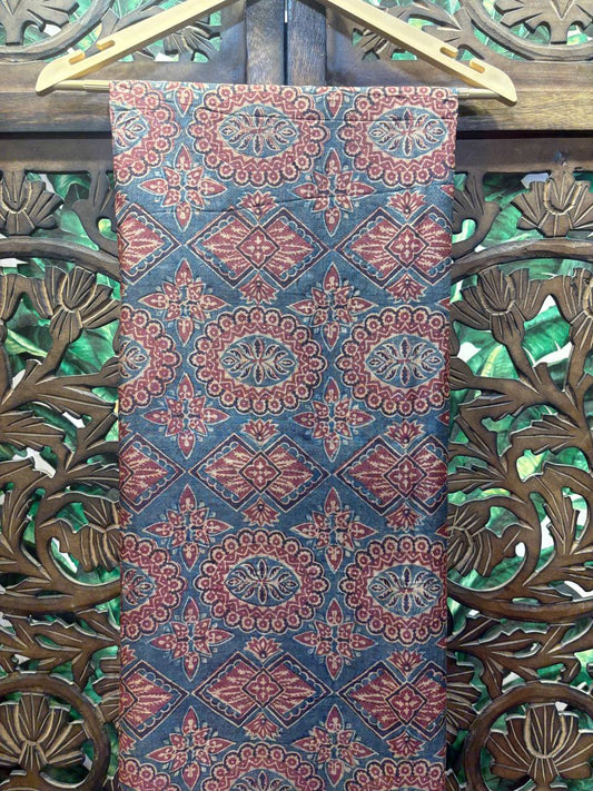 Close-up of the body of the Mihira saree showing the intricate Ajrakh hand block print with geometric and floral jaal patterns in maroon.