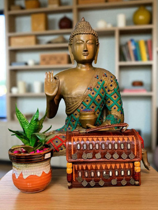 Unique ethnic leather bag with antique coins and wooden beads, styled next to a Buddha statue.
