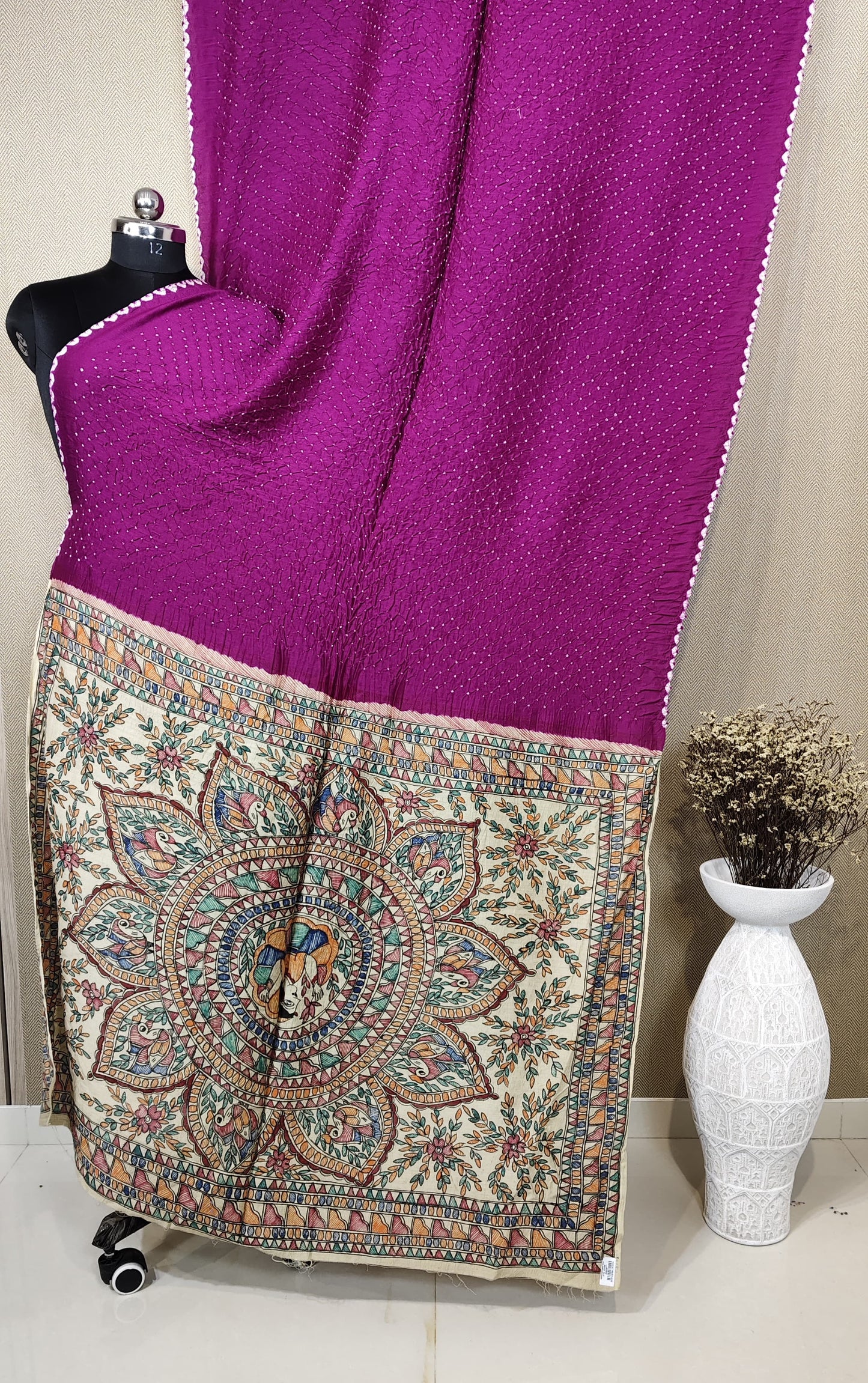 A premium Munga silk saree featuring a magenta Bandhani body and a hand-painted Kalamkari pallu with an intricate mandala and peacock design.