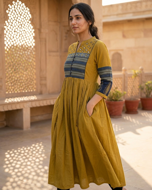 Woman wearing mustard cotton Anarkali kurta with printed yoke and pockets